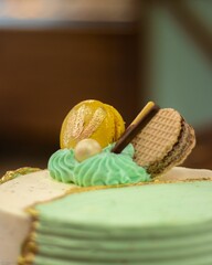 Closeup shot of a cake with cream in green and pink.