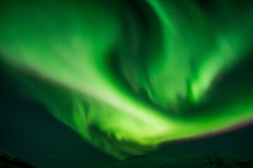 Beautiful shot of bright green aurora northern lights over mountains in Norway