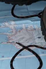 Vertical closeup shot of the map of Iceland with a shoe and laces on it - concept of travelling