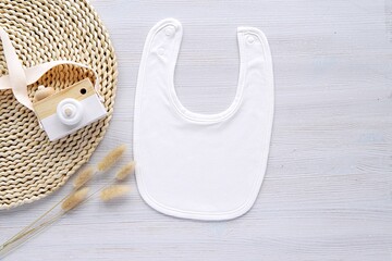 White plain fabric baby bib mockup for design or sayings presentation, aesthetic bohemian style flat lay composition.