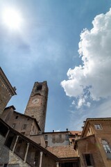 Fototapeta na wymiar Vertical low angle of the civic tower Campanone in the heart of Piazza Vecchia against a bright sky