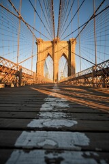 Vertical shot of the Brooklyn bridge in the early morning with sunshine on it in New York