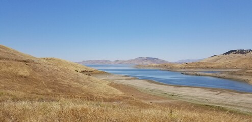 Beautiful hills landscape with a lake under a clear blue sky