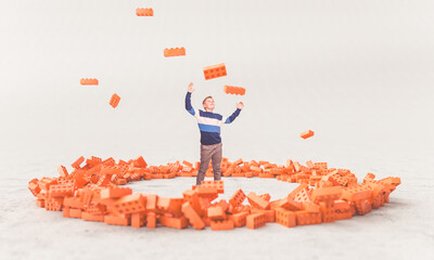 Joyful boy playing with toy bricks