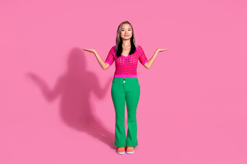 Full length photo of sweet shiny lady dressed knitted shirt comparing arms emtpy space isolated pink color background