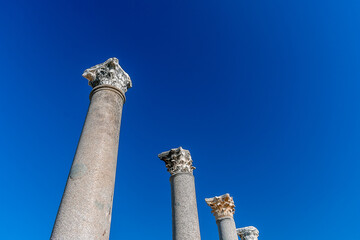 Antique columns against the blue sky. Minimalistic view of ancient columns against the sky.