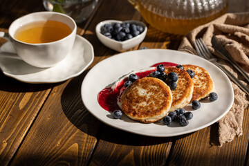 Breakfast with cheesecakes, pancakes with sour cream, mashed berries and fresh blueberries