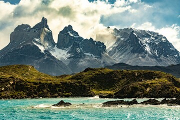 Image of a range of mountains behind a water surface with a beautiful sky in Torres del Paine, Chile