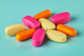 Closeup shot of colorful medicines and vitamins on the cyan background