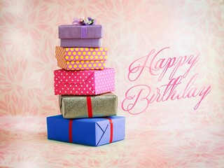 View of stacked gift boxes in floral background with 'happy birthday' text © Wirestock