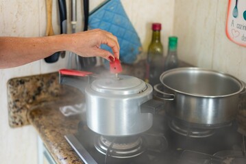Young female removing pressure from a stainless steel pot