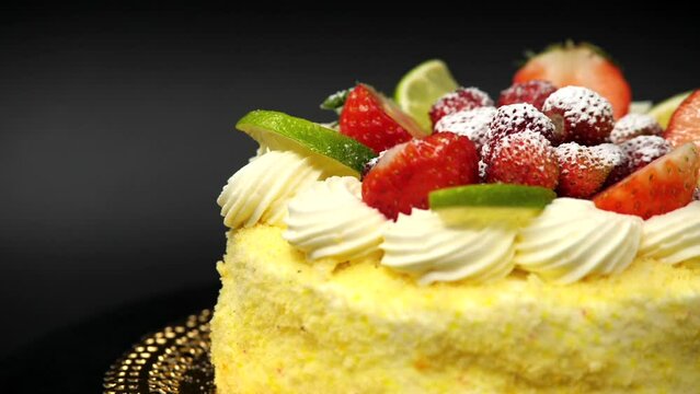 Torta mimosa con panna e fragole fresche.
Presentazione della torta nella pasticceria artigianale.