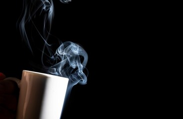 White cup with smoke against a black background