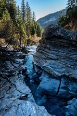 Vertical shot of a flowing river through the rocky mountains in Grisons, Switzerland