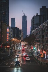Vertical shot of cars, lights and architectures in a street of Tang Qiao district at the evening