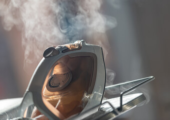Electric steam iron on a background of steam
