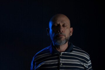 Bald man with beard wearing a casual shirt over black background closed eyes with Thoughts