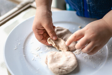 Child having fun modeling dough, authentic activity for fine motor skills development
