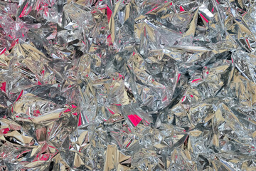 Beautiful abstract background made of aluminum foil with colored highlights.