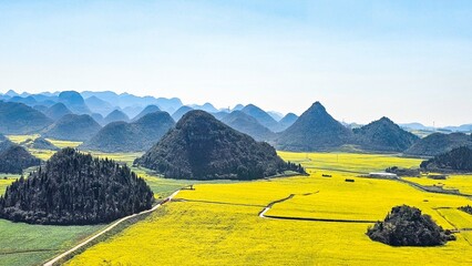 Scenic landscape with lush green fields and distant mountains in Loupin Rooster Hills, China