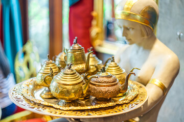 background of decorative items such as cups, plates, various animal statues, vintage sofas, that...