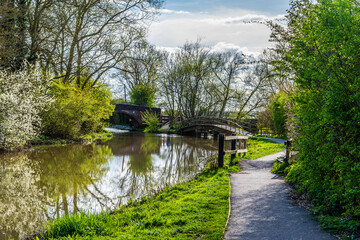 Fototapeta na wymiar A view towards footbridges over the Grand Union Canal in Aylestone Meadows, Leicester, UK in Springtime