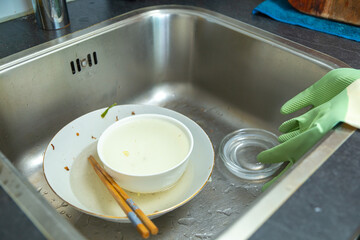 Unclean dishes and utensils in the sink, concept of kitchen leaning