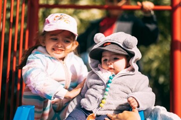 Closuep of two kids in the playground on a sunny winter afternoon