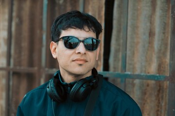 Young handsome male with black sunglasses and headphones
