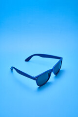 Blue sunglasses with a blue background.