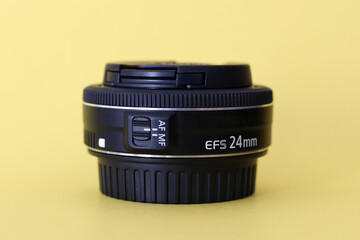 DSLR camera lens - digital camera lens 24 mm prime lens with yellow blurred background