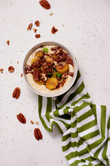 Oatmeal with caramel bananas and chocolate in to the bowl - 776042879