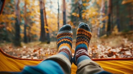 A person is sitting in a tent with their feet up and wearing socks - Powered by Adobe