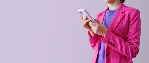 Business woman holding phone and standing against purple background. Empty space. Colorful image