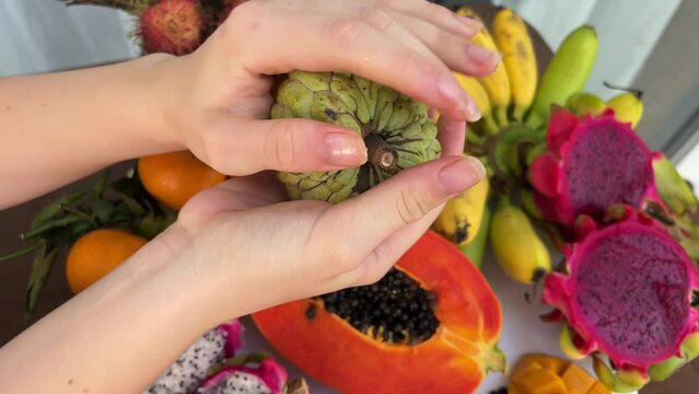 Hard unripe fruit Noah and trying to break it with your hands needs to finish ripening Assorted fresh ripe fruits and vegetables. Food concept background. Top view. 