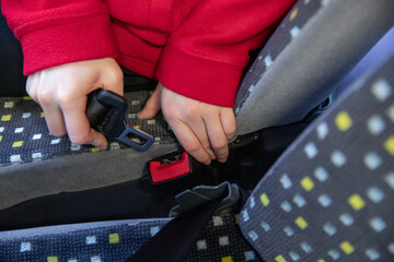 Gros plan d'un enfant attachant sa ceinture de sécurité dans un bus - obrazy, fototapety, plakaty