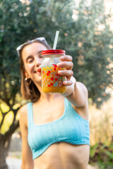 portrait of a girl in a bikini showing a juice