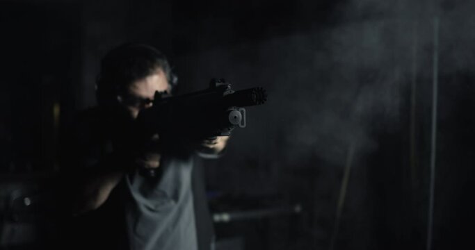Person firing a single shot with a shotgun in high-speed 800 fps slow-motion. Man shooting powerful impact gun