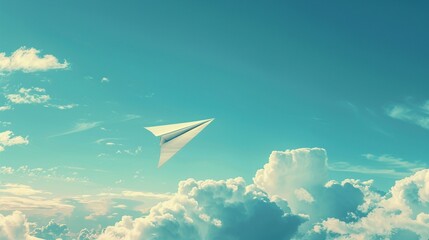 Naklejka na ściany i meble A lone paper airplane, a beacon of innovation, flies towards the horizon of a boundless blue sky, clouds dotting its path