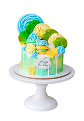 Colorful green and yellow beautiful birthday cake on white background with lollipops and meringues on the top