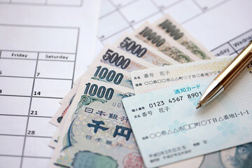 Japanese my number card specimen and notification card on calendar background with money close up