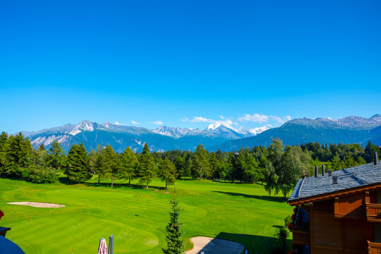 Panoramic View over Mountain with Snow and Weisshorn with 4505 Meters High and Golf Course with Clouds in Crans Montana, Valais in Switzerland.