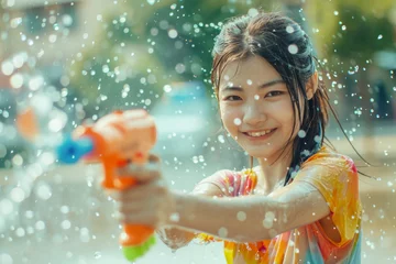Foto op Plexiglas Happy traveler asian woman wearing summer shirt holding colorful squirt water gun over blur city, Water festival holiday concept © grapestock