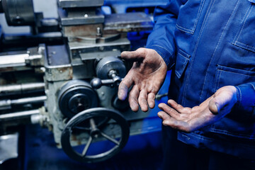 Working men with dirty hands stay near milling machine. Concept hard work of industry