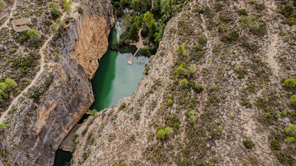 Luftaufnahme eines idyllischen blauen Sees mit Steg in der Schlucht von Chulilla, Spanien