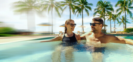 couple relaxing in hot tub by swimming pool at tropical resort. banner with copy space