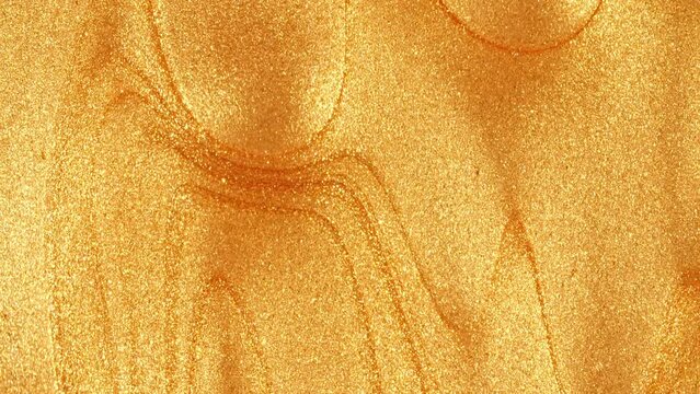 Liquid Gold Motion On The White Background. Macro Shot of Glitter Fluid Metallic Yellow Color Paint. Natural Organic Cosmetics, Medicine. Production Close-up. Slow Motion. High quality 4k footage