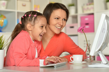 Close up porait of mother and daughter using laptop