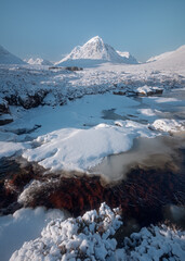 Frozen River Etive and a snow bank at in Glencoe in the Scottish Highlands. High quality photo