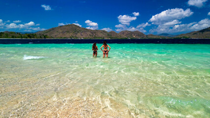 Back view of womand and daughter in the ocean